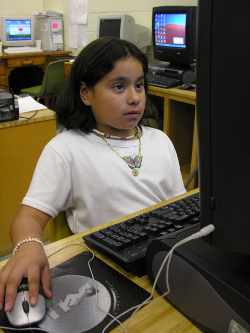 Niña ante un ordenador en un espacio público