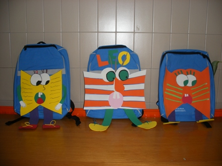 Imaxe de tres mochilas decoradas coma a mascota da biblioteca