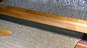 O peite apreta o novo f&iacute;o contra o xa tecido